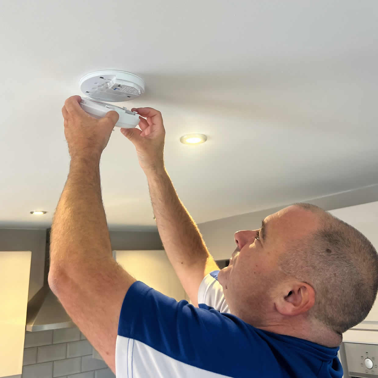 Smoke alarm installer fitting an alarm in a Hounslow property